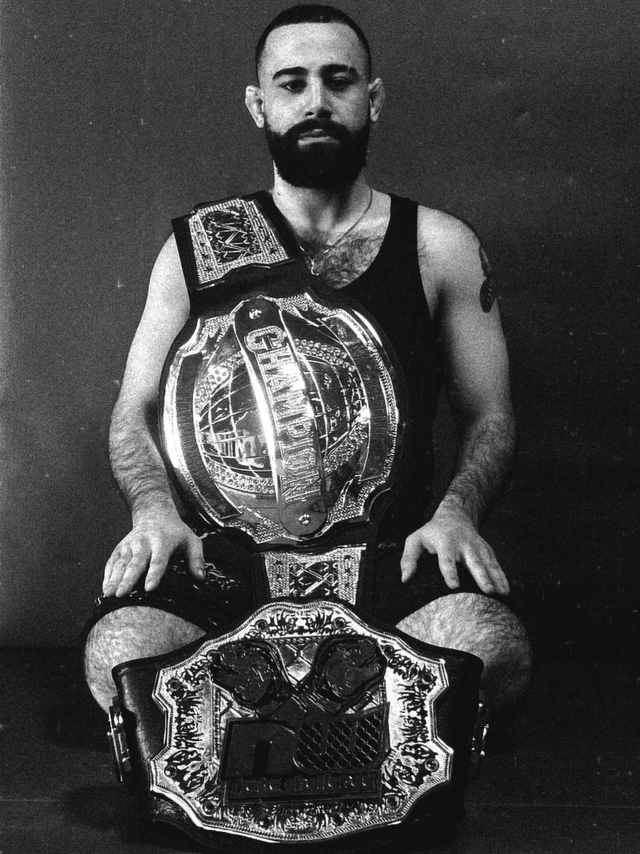 Michael Davtyan seated with his championship belt
